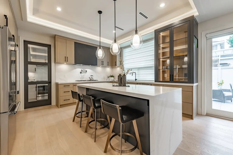 Modern kitchen with white island, black bar stools, wood cabinets, pendant lights, and glass-front upper cabinets